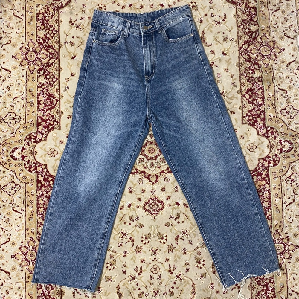 Distressed baggy blue jeans with frayed hem